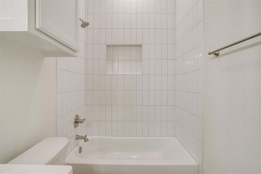 Bathroom featuring toilet and tiled shower / bath combo