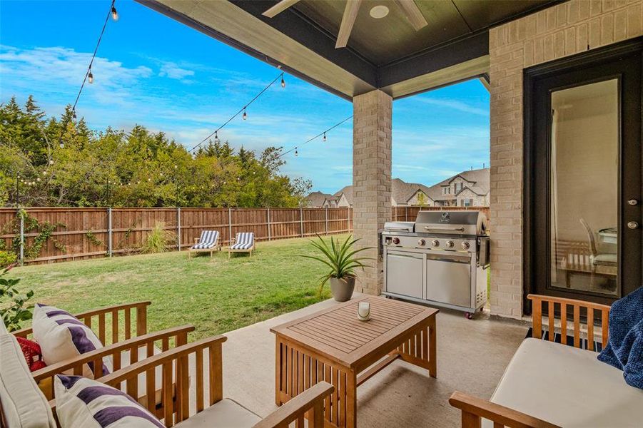 View of patio with area for grilling and ceiling fan