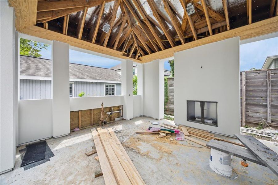 A sneak peek inside the detached backyard gazebo.  You will love this space with the vaulted ceiling, gas log fireplace with soon to be added cast stone surround and outdoor kitchen.  This will be one of many favorite spots of your new home!  Photo as of 9/3/2024