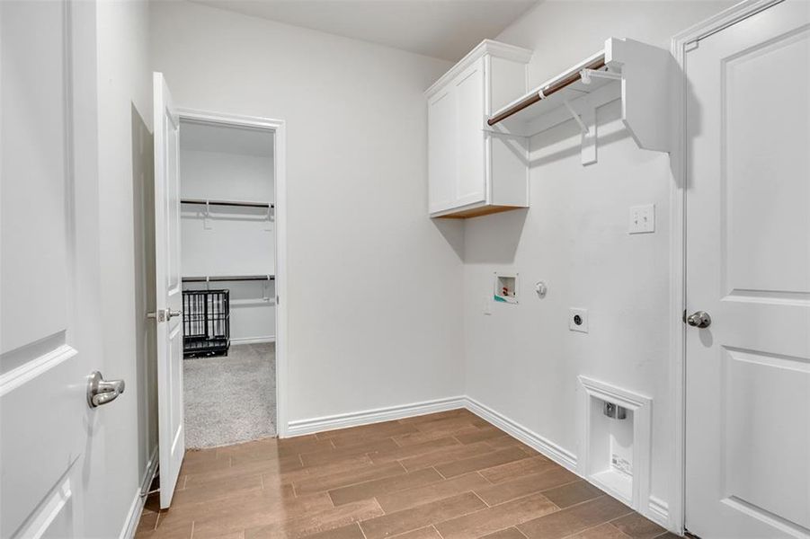 Spacious laundry and mudroom area featuring cabinets, carpet, electric dryer hookup, gas dryer hookup, and hookup for a washing machine