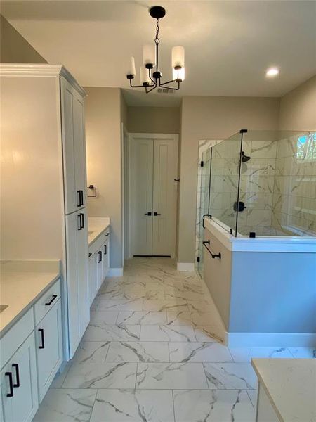 Bathroom featuring tile floors, an enclosed shower, vanity, and a notable chandelier