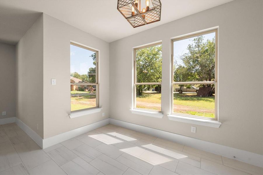 Unfurnished room featuring tile patterned flooring and a healthy amount of sunlight