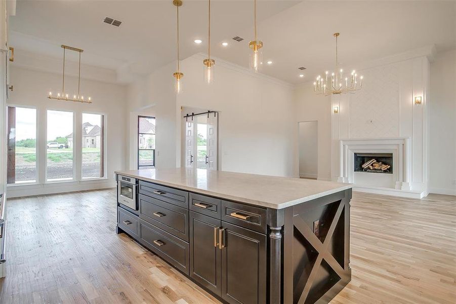 Kitchen with light hardwood / wood-style floors, a wealth of natural light, and a kitchen island