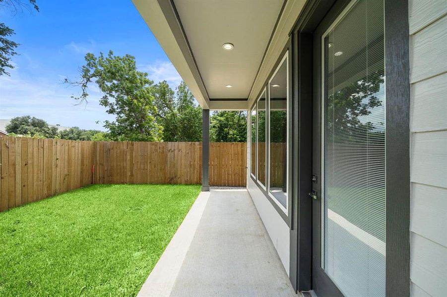 Modern covered patio providing a seamless transition to the yard, perfect for grilling in the shade.