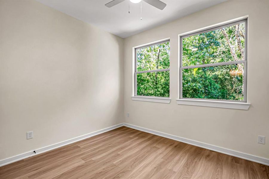 Guest bedroom is bright with windows overlooking the backyard.