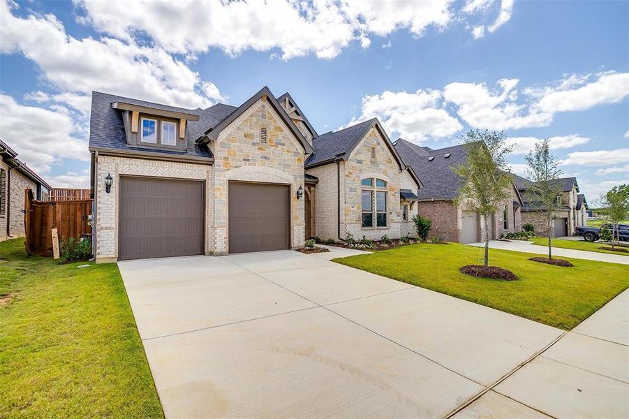 View of front of house with a garage and a front yard