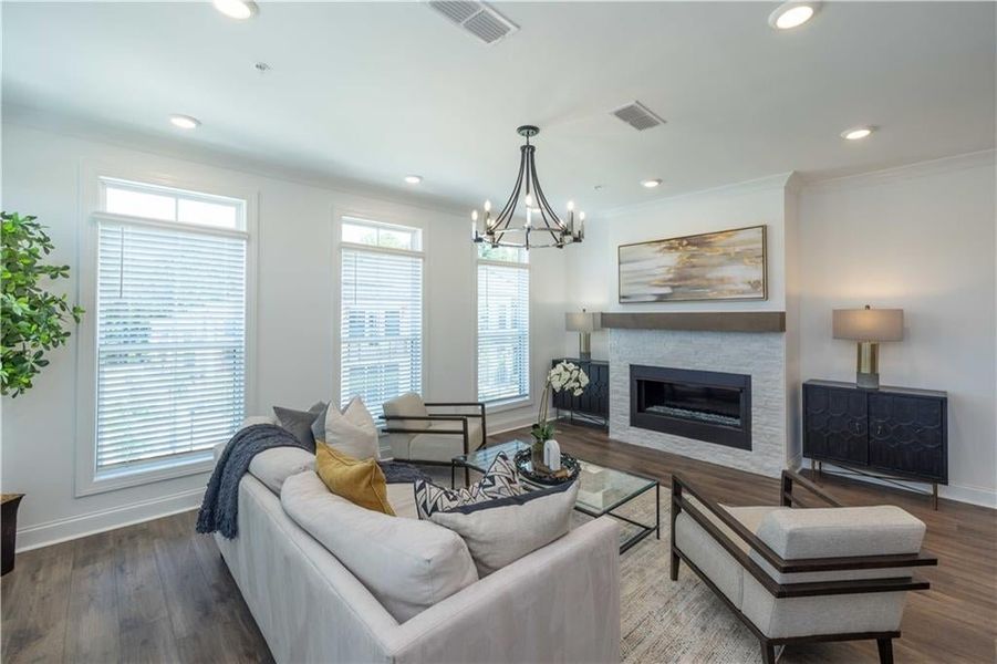 Living room with crown molding, dark hardwood / wood-style flooring,and a Linear Fireplace , not the actual unit