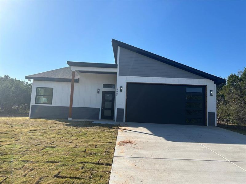 View of front of home featuring a front lawn and a garage