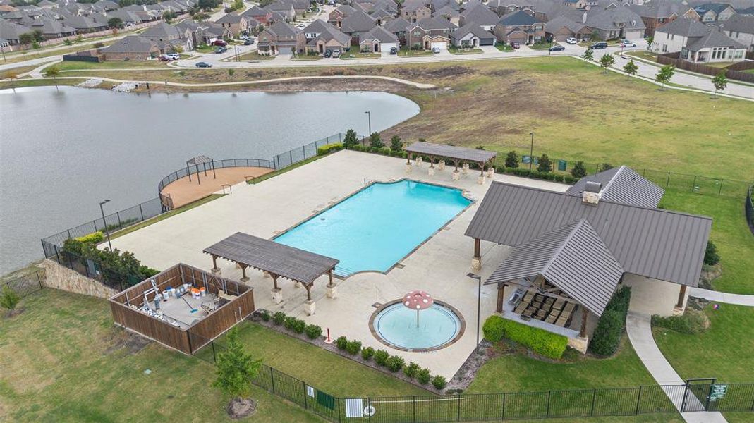 View of pool with a patio, a yard, and a water view