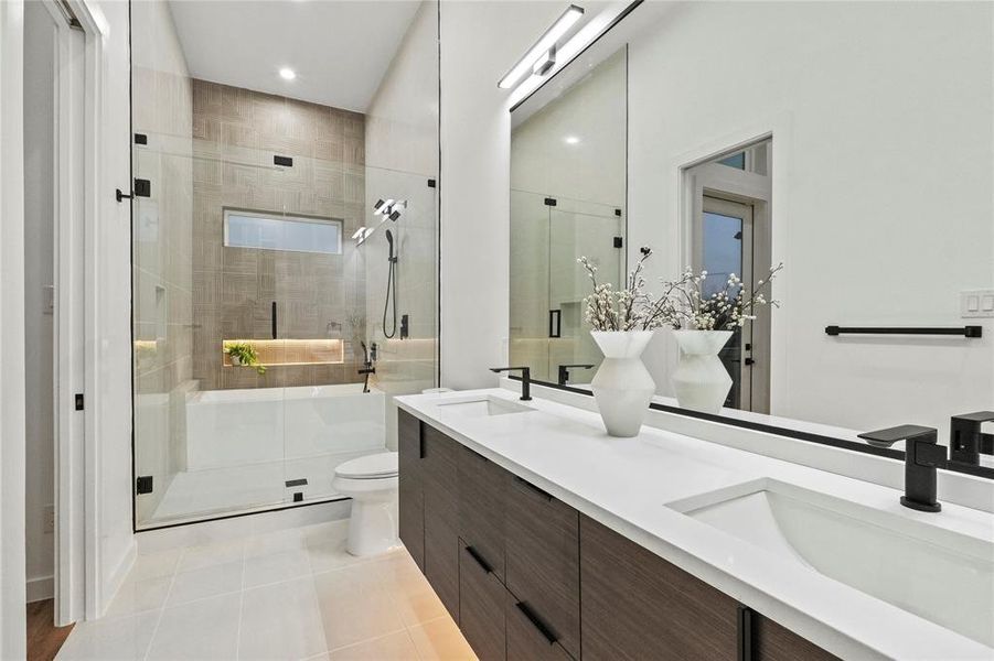 Bathroom featuring an enclosed shower, tile patterned flooring, toilet, and vanity