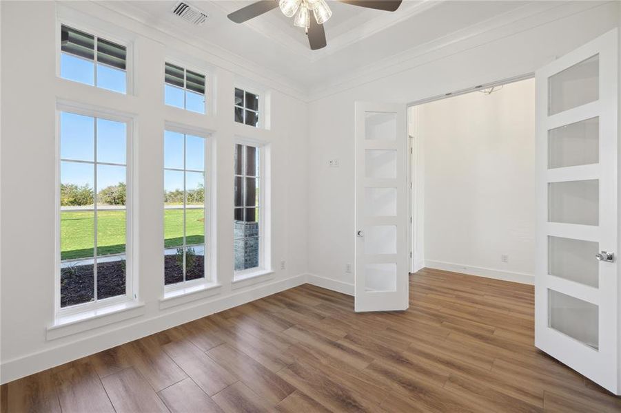 Empty room with ornamental molding, hardwood / wood-style floors, and ceiling fan