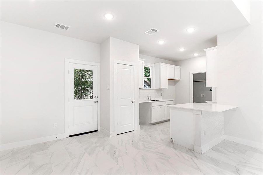 Kitchen connects to breakfast/dining room and utility room.