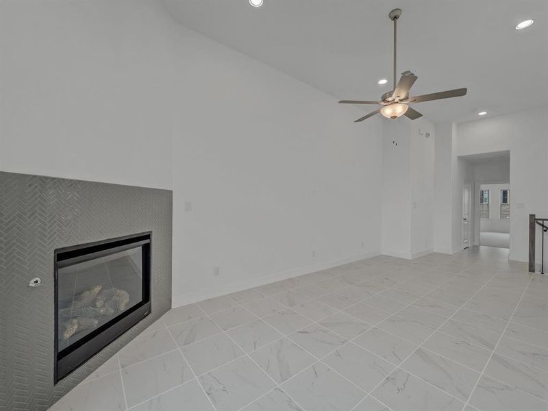 Unfurnished living room with ceiling fan and light tile floors
