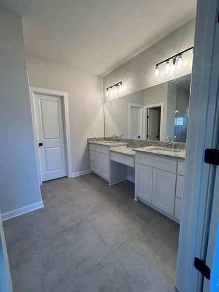 Bathroom with a shower, vanity, and concrete flooring