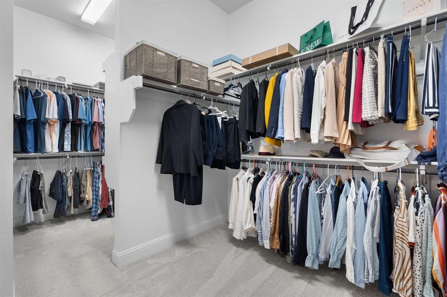 Primary Walk in closet featuring double clothes racks and storage space