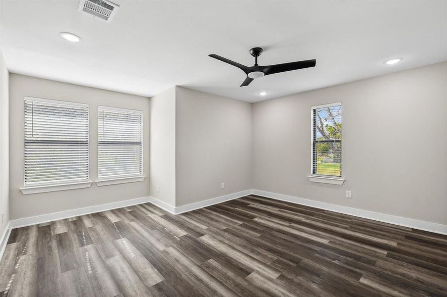 Empty room featuring dark wood-type flooring and ceiling fan