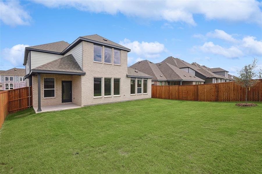 Rear view of property with a yard and a patio