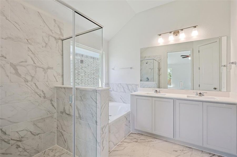 Bathroom with lofted ceiling, separate shower and tub, vanity, and ceiling fan