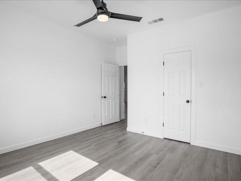 Unfurnished bedroom with ceiling fan and wood-type flooring