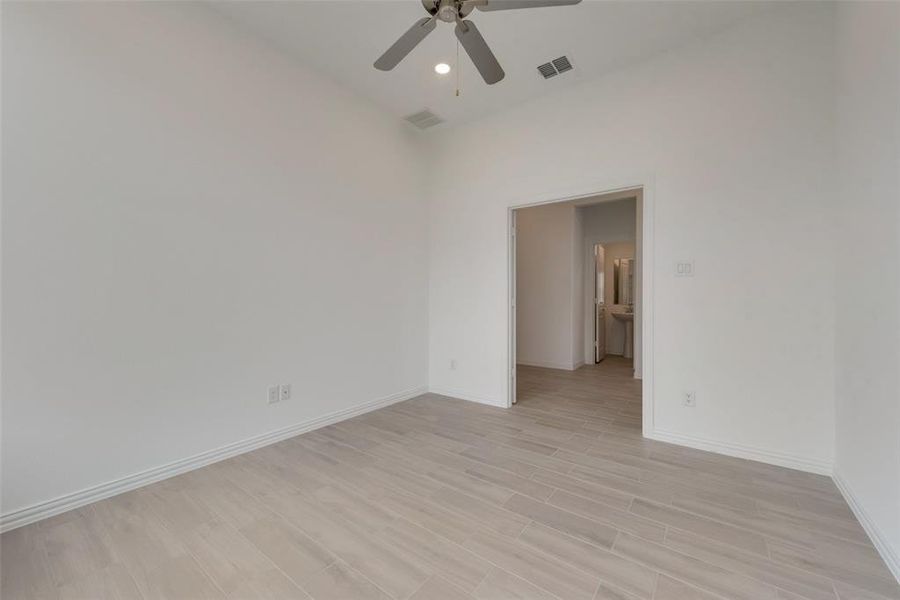 Unfurnished room with ceiling fan and light wood-type flooring