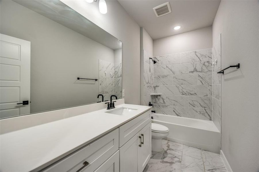 Full bathroom with tiled shower / bath combo, and vanity