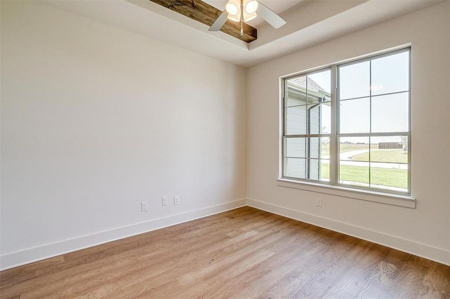 Unfurnished room with a healthy amount of sunlight, wood-type flooring, and ceiling fan