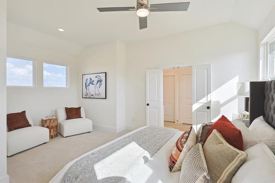 Bedroom with lofted ceiling, ceiling fan, and light colored carpet