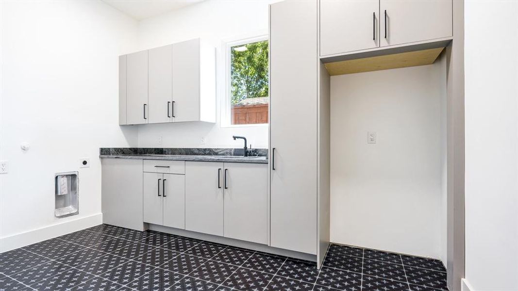 Kitchen with white cabinets, heating unit, and sink