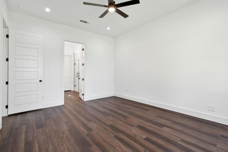 Empty room with dark wood-type flooring and ceiling fan