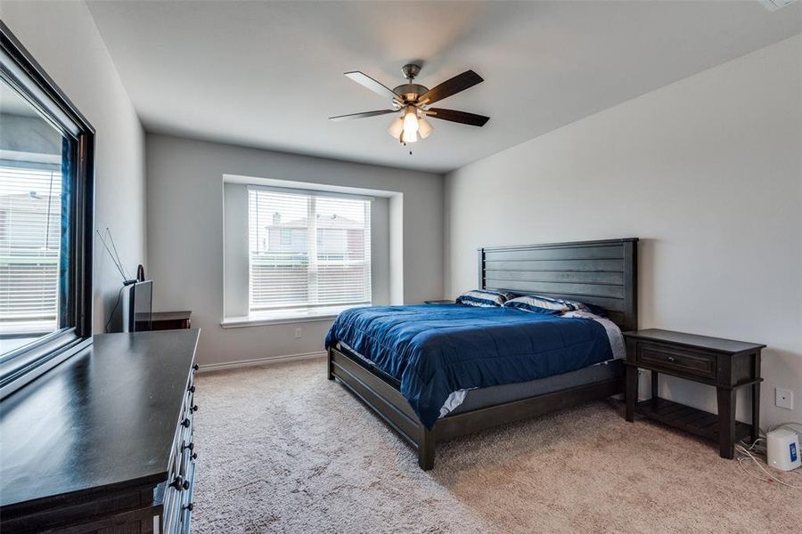 Carpeted bedroom featuring ceiling fan