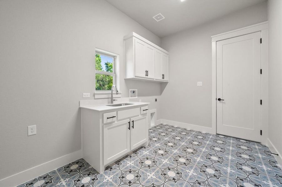 Laundry area featuring cabinets & sink!