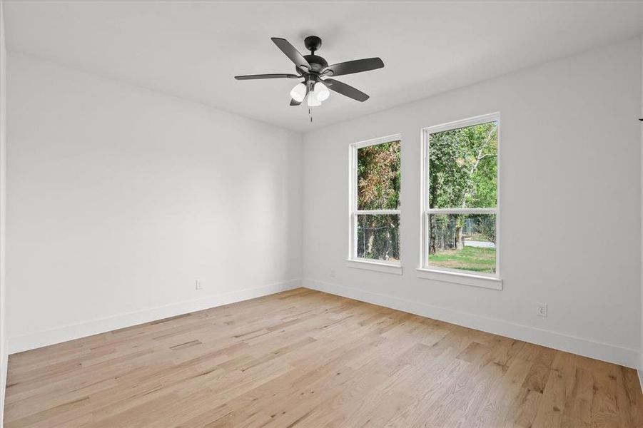 Spare room featuring ceiling fan, plenty of natural light, and light hardwood / wood-style floors