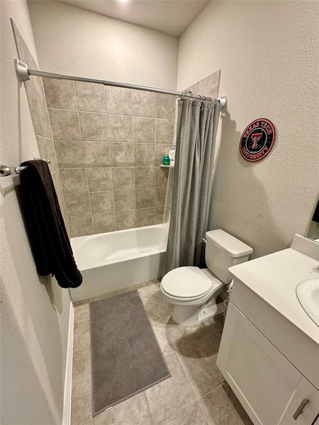 Full bathroom with vanity, toilet, shower / tub combo, and tile patterned floors