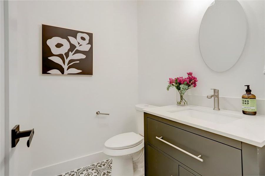 The half bath has custom tile floor, contemporary solid-wood cabinets, and elegant 3cm quartz counters.