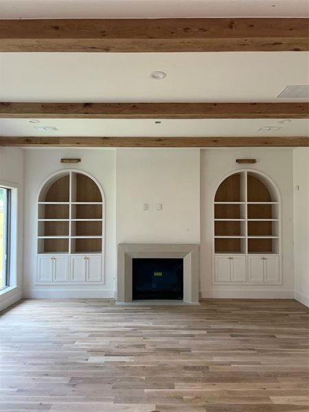 Living room with gas fireplace, custom cast stone mantel, built in cabinetry, Visual Comfort lighting and reclaimed oak beams.