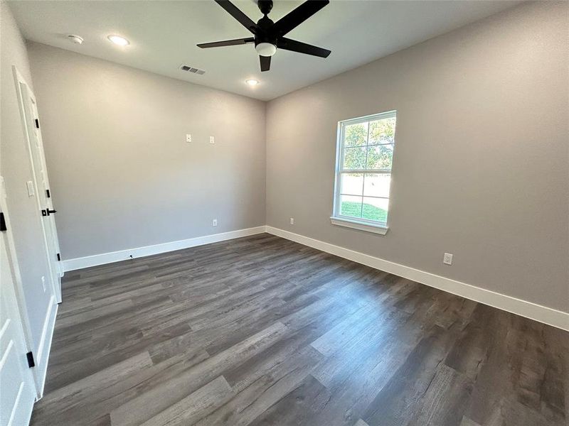 Spare room with ceiling fan and dark wood-type flooring