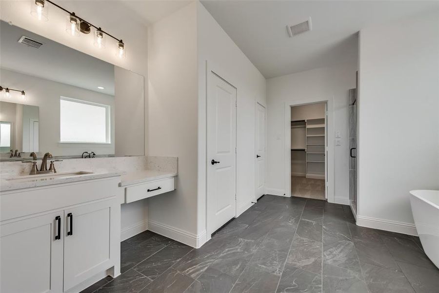 Bathroom with tile floors, a bath to relax in, and oversized vanity