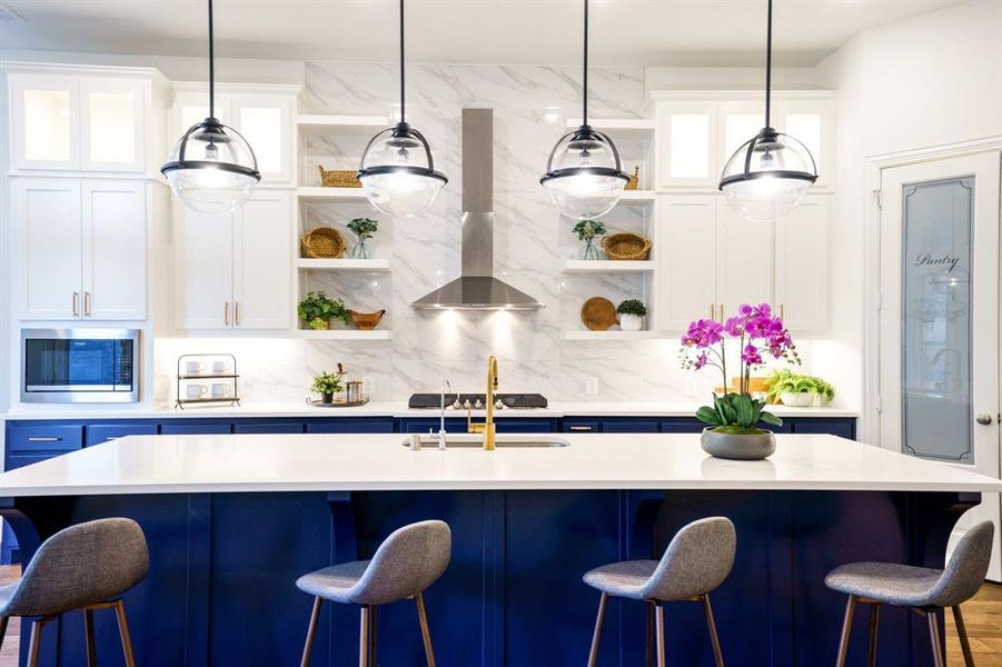 Bar featuring white cabinetry, island exhaust hood, stainless steel microwave, and pendant lighting