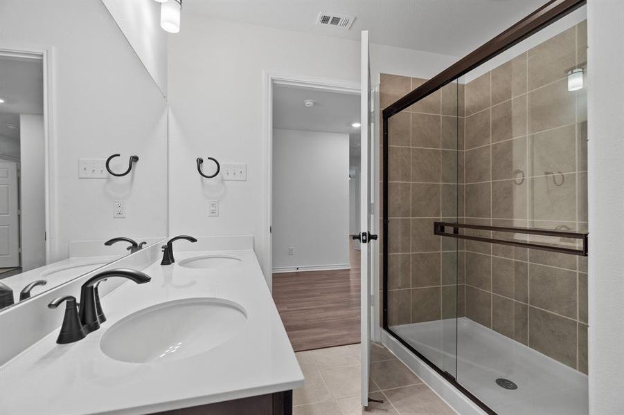 Bathroom with an enclosed shower, vanity, and wood-type flooring