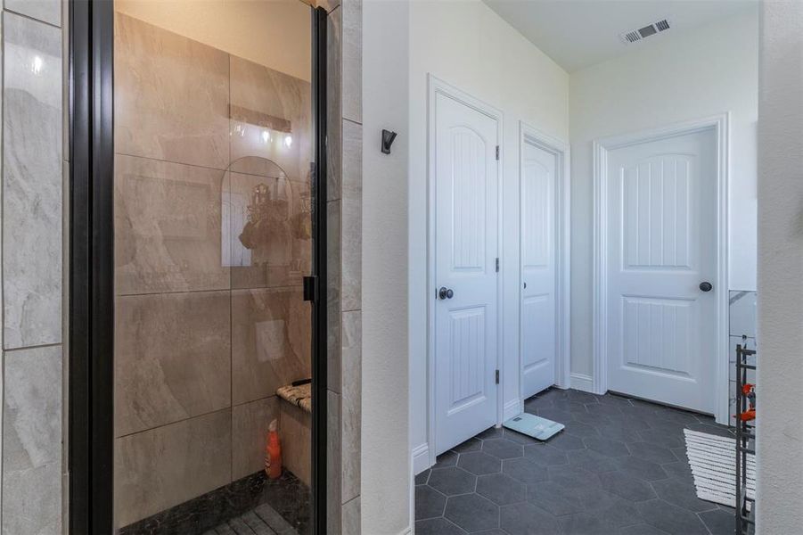 Bathroom with tile patterned flooring and a shower with shower door