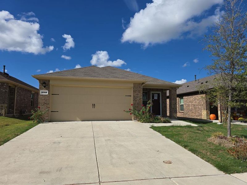 View of front facade featuring a garage and a front yard