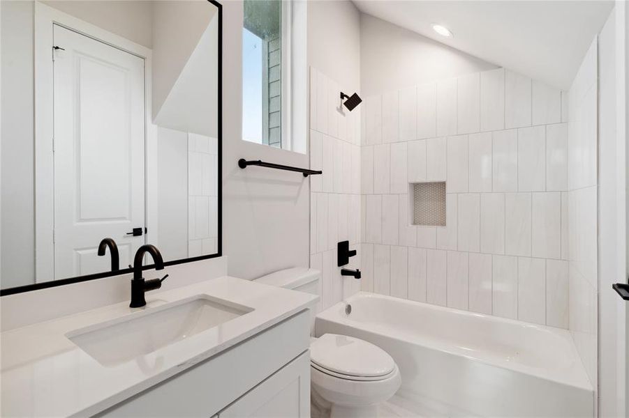 The first floor bathroom features matte finishes along with designer tile that embodies the full size tub and shower.