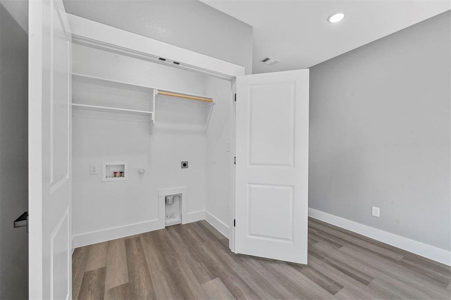 Laundry room with light hardwood / wood-style flooring, hookup for a gas dryer, electric dryer hookup, and hookup for a washing machine