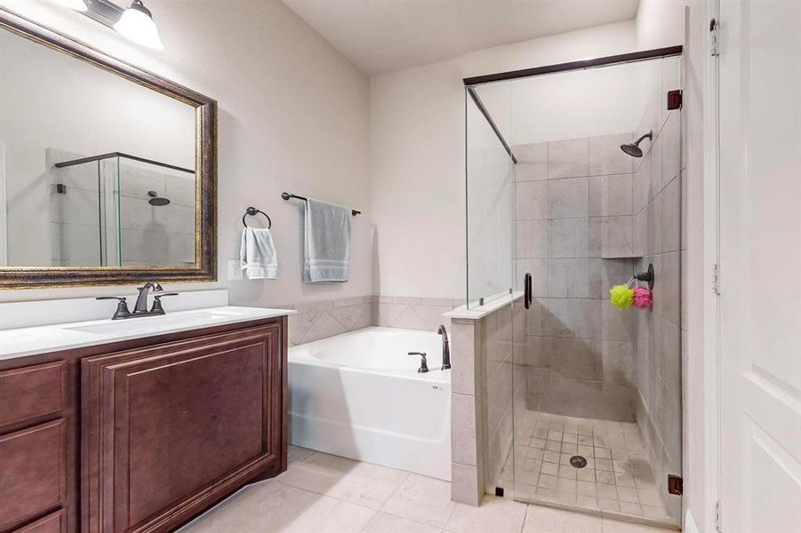 Bathroom featuring vanity, plus walk in shower, and tile patterned flooring