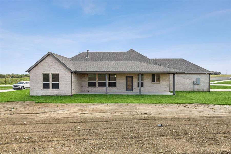 View of front of house featuring a front lawn and a patio