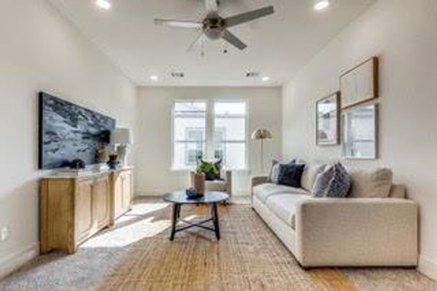 Carpeted living room with ceiling fan