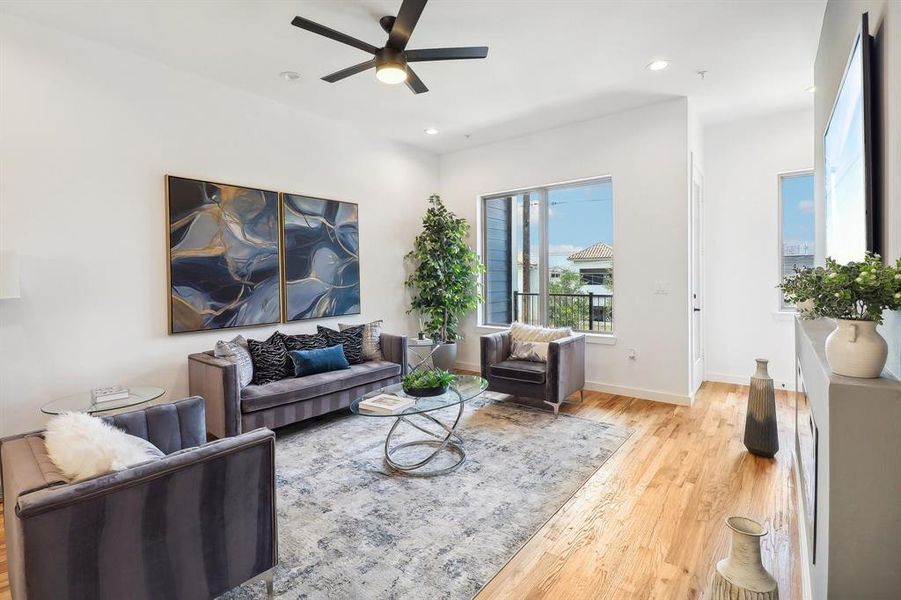 Living room with light wood-type flooring and ceiling fan