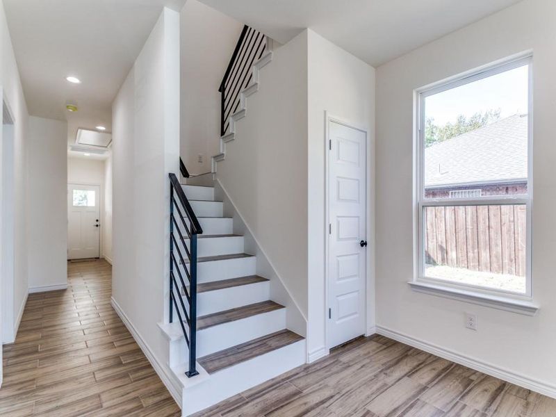 Staircase with wood-type flooring and plenty of natural light