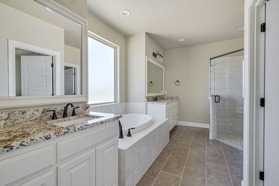 Bathroom with vanity, a healthy amount of sunlight, independent shower and bath, and tile patterned floors