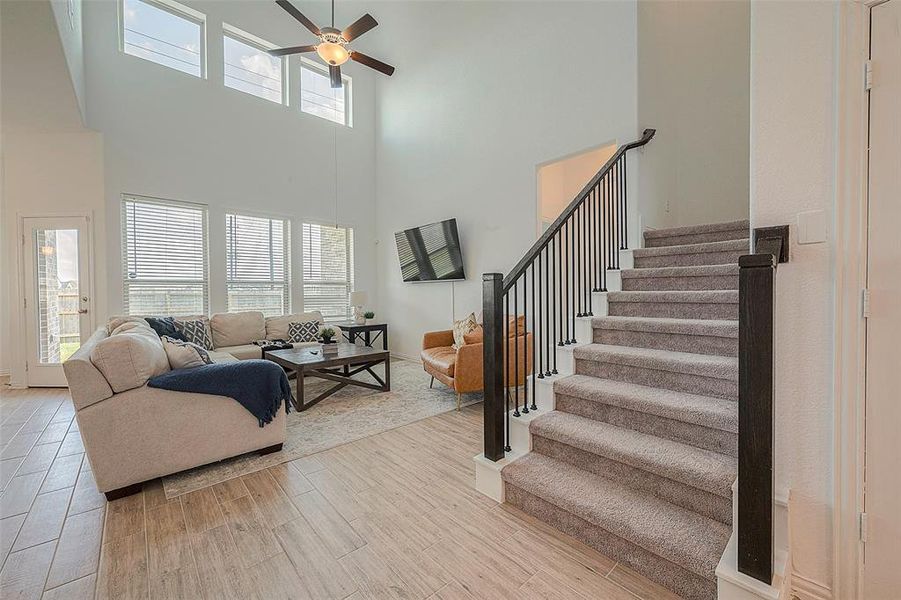 This spacious living room features an open floor plan and a staircase leading to the upper level. The openness creates a light and airy feel, perfect for entertaining.